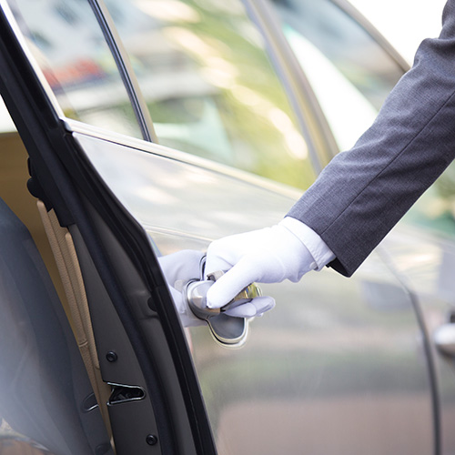 A chauffer opens the door for a passenger of everyday limo service.